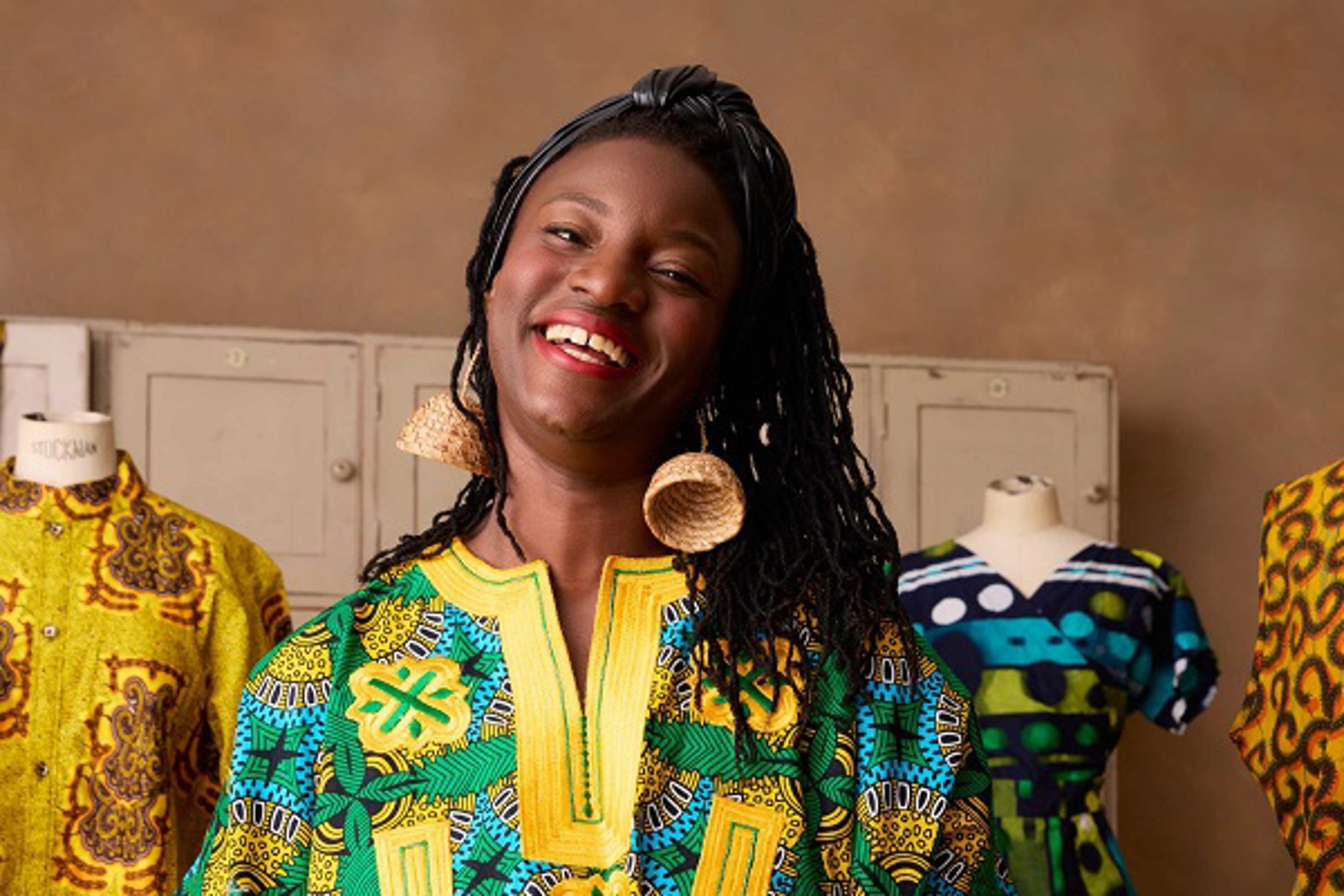 Women Standing Infront Of Colourful Clothes