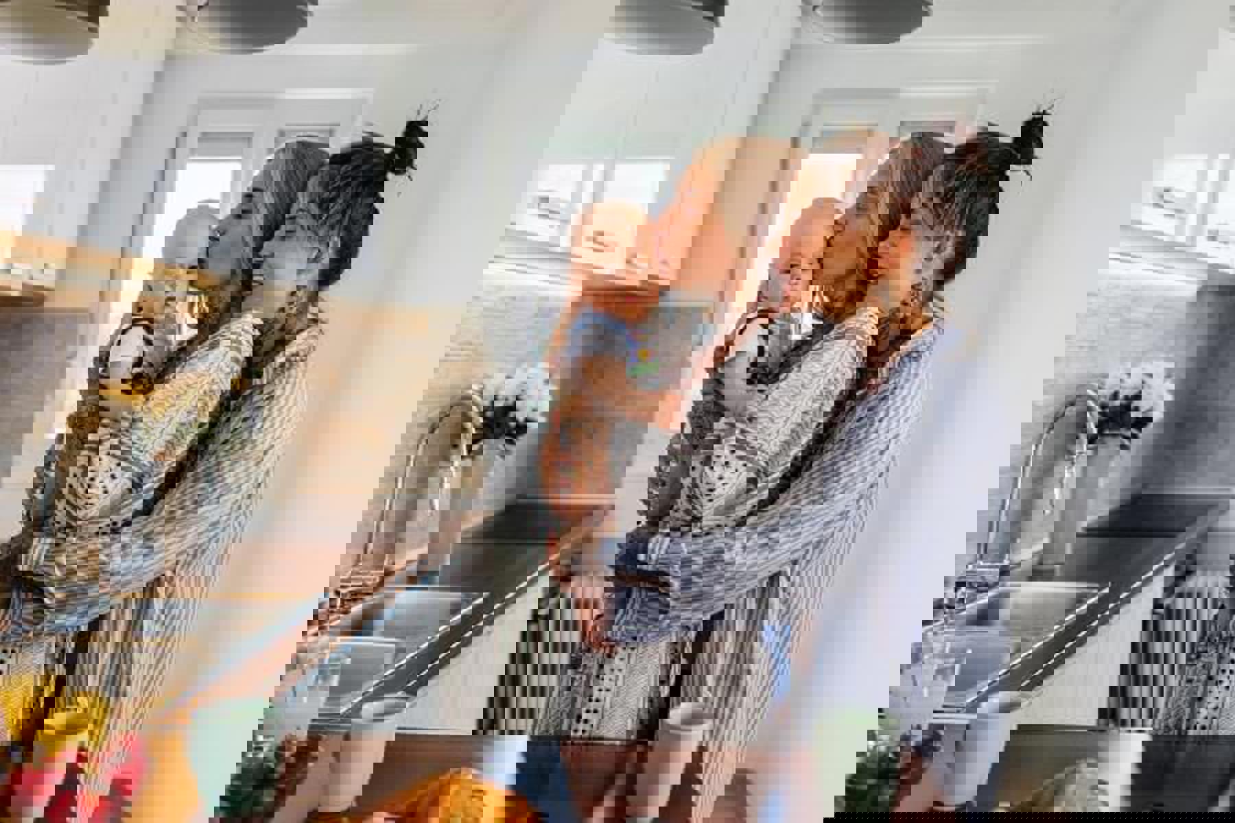 Couple In Kitchen Hugging Kissing Baby