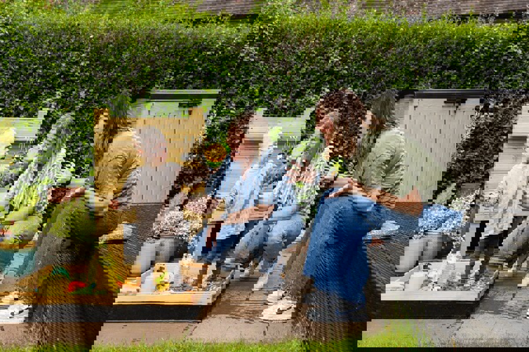 Couple Playing With Baby Outside Sand Pit